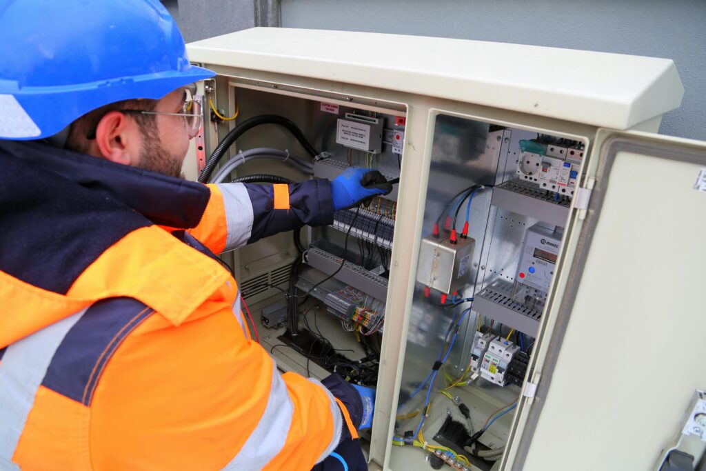 Electrician working on a power distribution box – essential protection with business insurance for electrical contractors.
