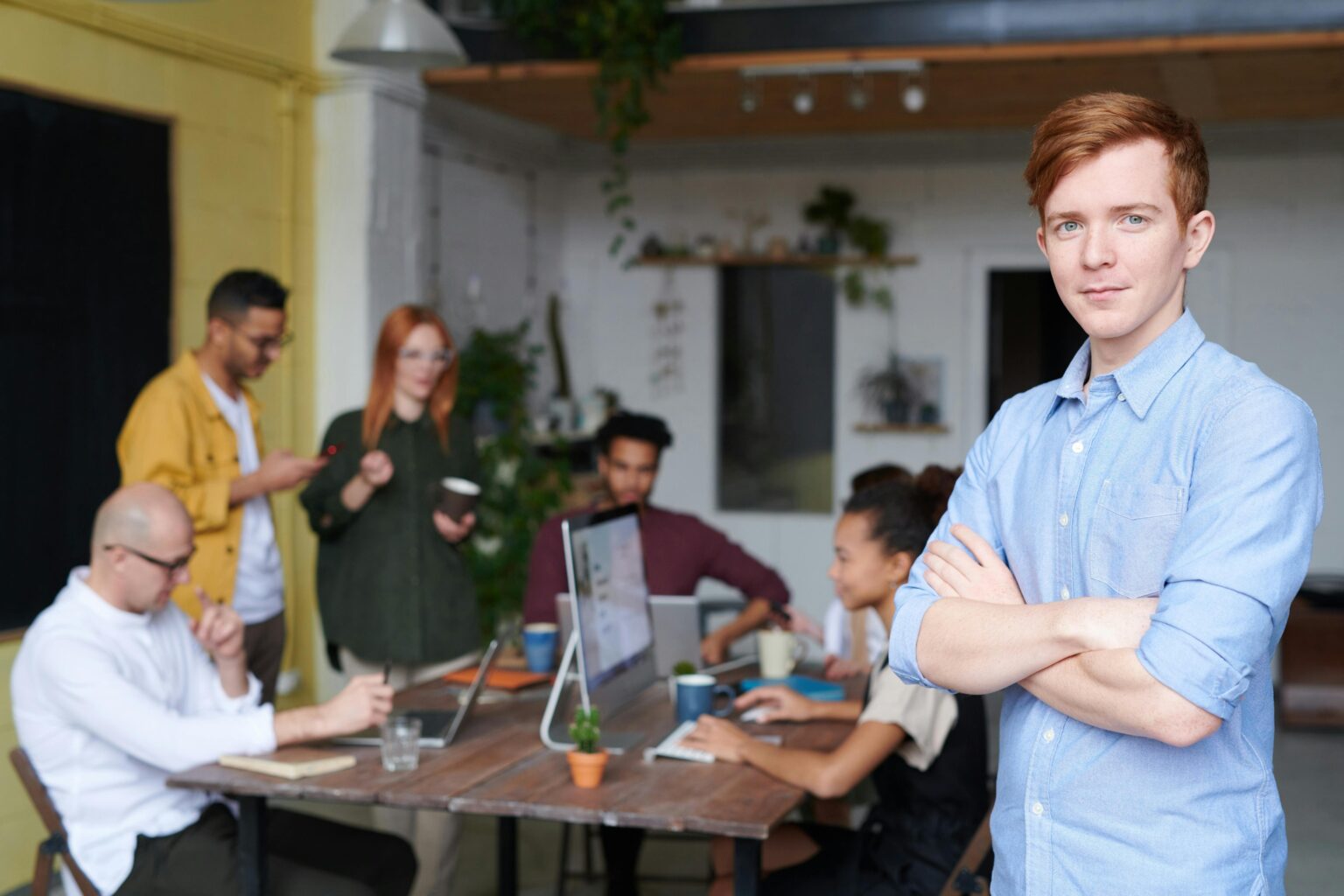 Young entrepreneur standing confidently in front of a collaborative team meeting—an inspiring example of how to start a CPA firm successfully in today’s business environment.